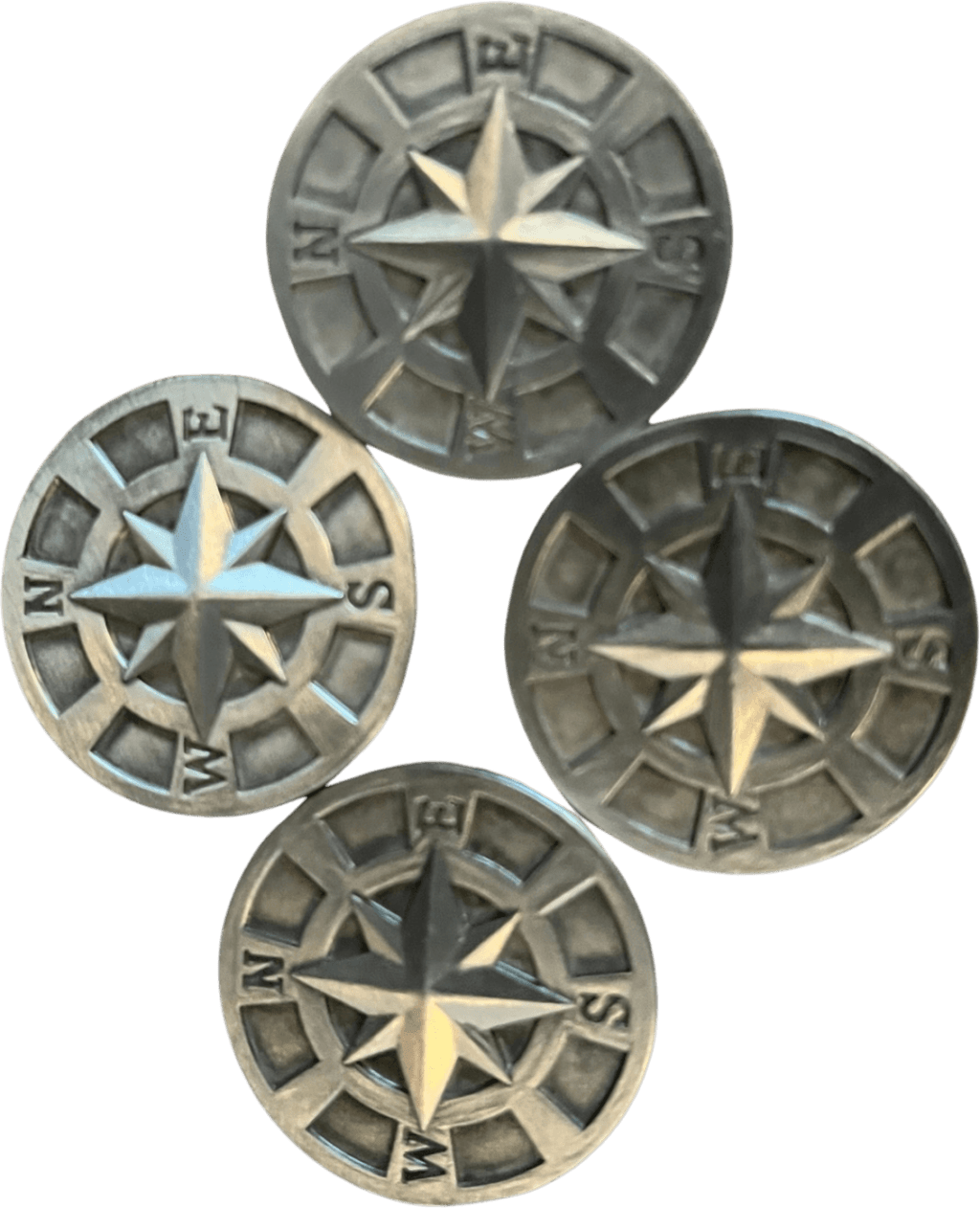 Four metal compass buttons on a black background for home decor.